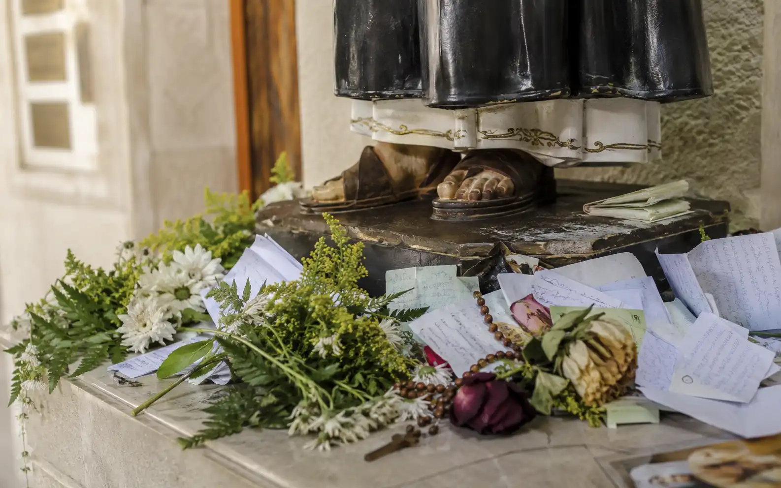 Pedidos escritos y una oración a San Cayetano sobre una mesa