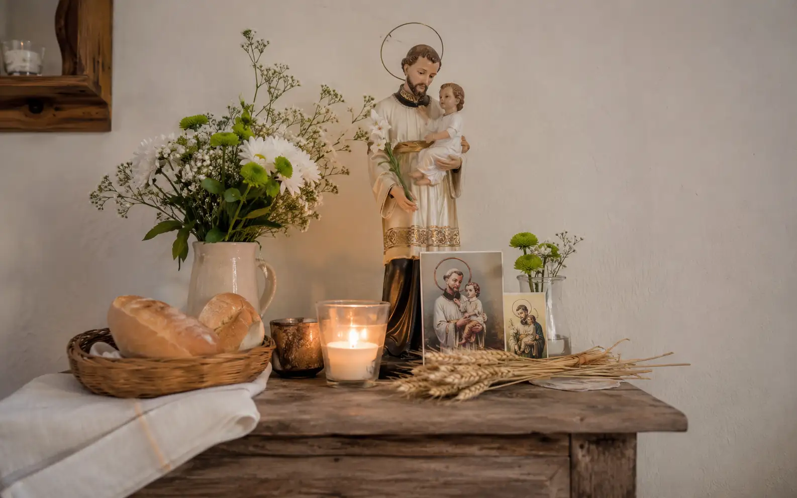 Vela, pan y espiga en una escena devocional vinculada a San Cayetano
